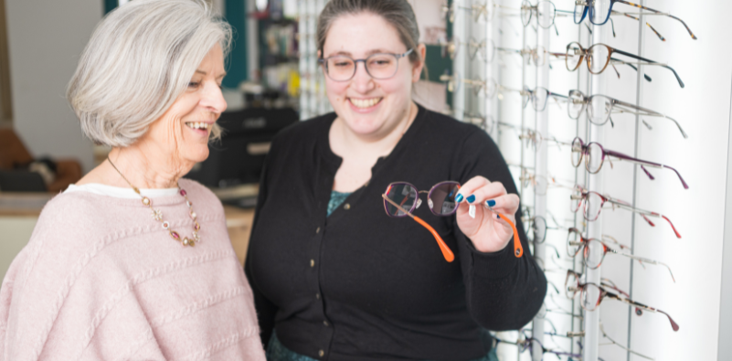 A professional eyewear stylist showcasing eyewear to a patient