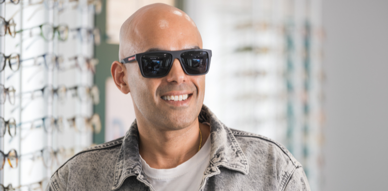 A patient trying on a pair of sunglasses during a personalised eyewear consultation.